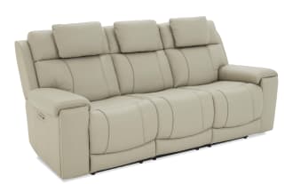 Beige leather reclining sofa with three seats, padded headrests, and cushioned armrests, designed for living room comfort and style.