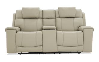Beige leather reclining loveseat with padded armrests, adjustable headrests, and a central console for storage or cup holders, designed for comfort and style.