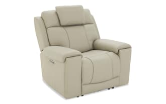 Beige leather recliner chair with padded armrests, cushioned headrest, and ergonomic stitching, designed for comfort and relaxation.