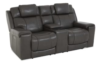 Dark gray leather reclining loveseat with padded armrests, high backrests, and a center console for storage and cup holders.
