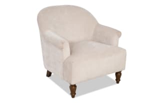Beige upholstered armchair with rounded back and rolled arms, featuring dark wooden turned legs, suitable for living room seating.