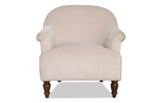Beige upholstered armchair with rounded back and rolled arms, featuring dark wooden turned legs, suitable for living room seating.