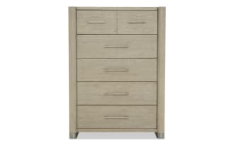 Tall light oak wood dresser with five drawers, featuring modern metal handles and rounded vertical side panels, ideal for bedroom storage.