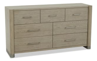 Six-drawer wooden dresser in light oak finish with modern metal handles, rounded corners, and metal-capped legs, ideal for bedroom storage.