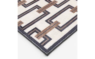 Rectangular area rug with a modern geometric pattern featuring interlocking brown and black rectangular chains on a cream background, suitable for contemporary home decor.