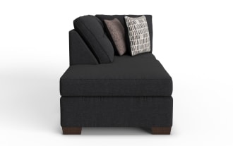 Modern black fabric chaise lounge with wooden legs, tufted back cushions, and two decorative throw pillows in neutral tones, ideal for living room seating.
