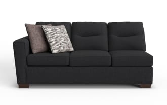 Dark gray fabric three-seater sofa with wooden legs, featuring two decorative throw pillows in brown and patterned beige.