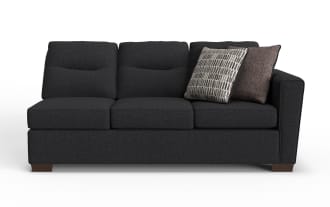 Dark gray fabric three-seater sofa with wooden legs, featuring two decorative throw pillows in patterned and solid brown fabric.