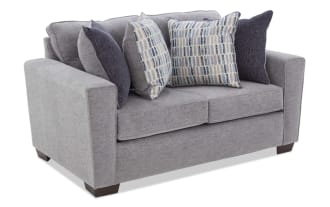 Gray fabric loveseat with two patterned blue and beige cushions and two solid dark blue cushions, featuring a modern design and wooden legs.