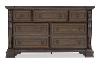 Traditional wooden dresser with dark brown finish, ornate carved details, and nine drawers featuring decorative metal handles, ideal for bedroom storage.