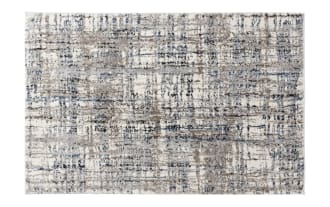 Area rug with an abstract pattern in shades of beige, blue, and gray on a white background, featuring a textured, modern design.