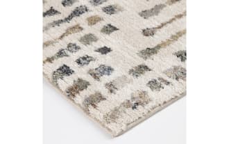 Rectangular area rug with a modern abstract pattern in neutral tones of beige, gray, and taupe on a cream background, featuring a textured, soft pile surface suitable for living rooms or bedrooms.