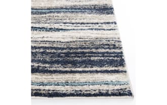 Rectangular area rug with a striped pattern in shades of blue, gray, black, and white, featuring a textured, plush material suitable for modern home decor.