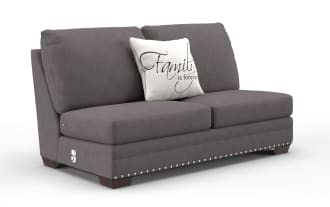 Gray fabric loveseat sofa with dark wooden legs and silver nailhead trim, featuring a white decorative pillow with the text "Family is forever."