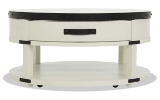 Round white wooden coffee table with black metal accents, a single drawer with black handle, and a lower shelf for storage.
