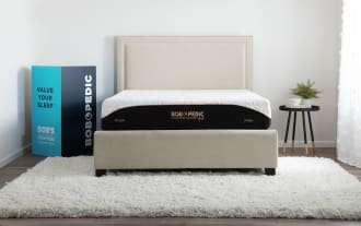 Queen-sized Copper Sport Gel 11.5" mattress by Bob-O-Pedic with black and white cover, copper gel memory foam, beige upholstered bed frame, and plush-firm firmness labels.