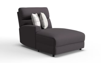 Modern dark gray fabric chaise lounge chair with a cushioned backrest, one armrest on the left, and two decorative white pillows with striped and checkered patterns.