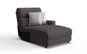 Dark gray upholstered chaise lounge chair with cushioned backrest, single armrest on right side, and two decorative white pillows with striped and checkered patterns.