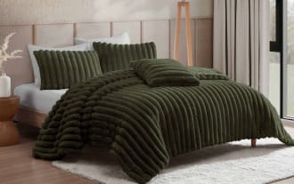 Luxurious dark green plush ribbed comforter set on a modern bed with matching pillows, soft textured bedding for cozy bedroom decor.