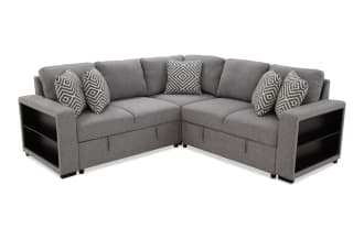 Gray fabric sectional sofa with black wooden side shelves, featuring six geometric patterned throw pillows, designed for modern living rooms.