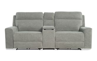 Modern gray fabric reclining loveseat with padded armrests and a center console storage compartment, ideal for living room comfort.