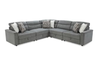 Gray fabric sectional sofa with adjustable headrests, plush cushions, and patterned throw pillows, designed for modern living rooms.
