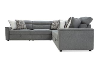 Gray fabric sectional sofa with adjustable headrests, plush cushions, and patterned throw pillows, designed for modern living rooms.