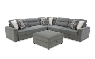 Gray fabric sectional sofa with chaise lounge, plush cushions, and patterned throw pillows, showcasing modern, comfortable living room furniture.