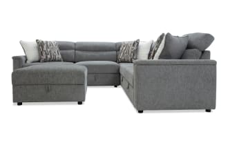 Gray fabric sectional sofa with chaise lounge, plush cushions, and patterned throw pillows, showcasing modern, comfortable living room furniture.
