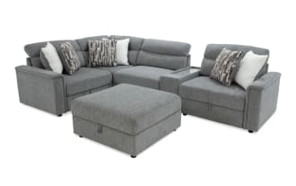 Gray fabric sectional sofa with adjustable headrests, patterned and white throw pillows, and a matching ottoman, ideal for modern living rooms.