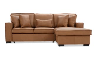 Modern L-shaped sectional sofa in tan leather with tufted cushions and matching throw pillows, featuring a chaise lounge on the right side.