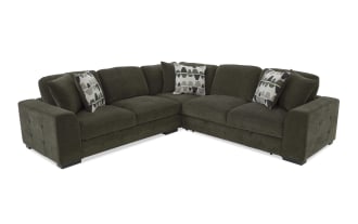 Dark green fabric sectional sofa with tufted armrests, thick cushions, and three patterned throw pillows, designed for modern living rooms.