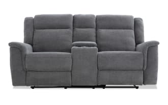 Gray fabric reclining loveseat with center console and cup holders, featuring padded armrests and cushioned back support for living room comfort.