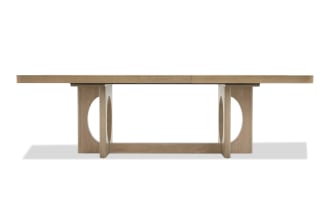 Rectangular wooden dining table with a light oak finish, featuring a modern design with circular cutouts on the sturdy legs and a smooth, flat tabletop.