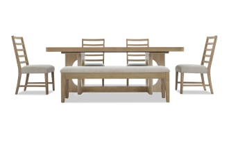 Dining set with light wood finish including rectangular table, four ladder-back chairs with beige upholstered seats, and a matching bench.