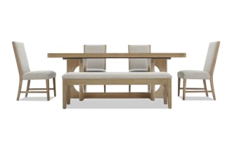 Dining set with light wood finish, featuring a rectangular extendable table, four beige upholstered chairs, and a matching bench with cushioned seat.
