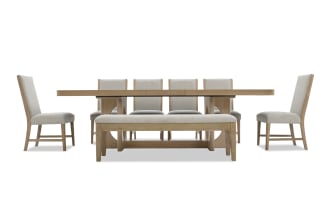 Dining set with a natural wood rectangular table, four beige upholstered chairs with wooden legs, and a matching cushioned bench.