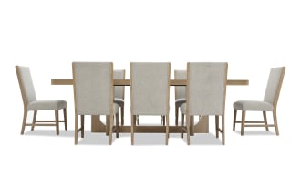 Dining set with eight beige upholstered chairs featuring wooden frames and a rectangular wooden table with a sturdy base, ideal for modern dining rooms.