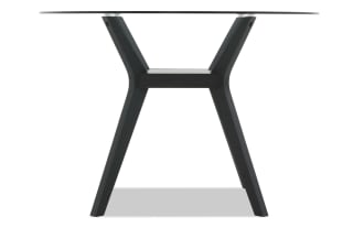 Modern round glass-top table with black wooden angled legs and a small rectangular shelf, ideal for contemporary dining or office spaces.