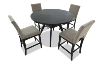 Round black wood dining table with four beige upholstered high-back chairs, featuring cushioned seats and sturdy black wooden legs, suitable for modern dining rooms.