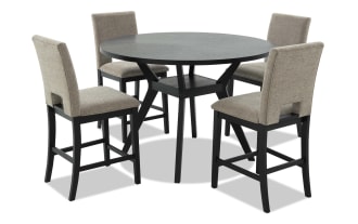 Round black wood dining table with four beige upholstered high-back chairs, featuring cushioned seats and sturdy black wooden legs, suitable for modern dining rooms.