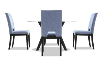 Dining set with four light blue upholstered chairs featuring black wooden legs and a glass-top table with black angled supports, modern style.