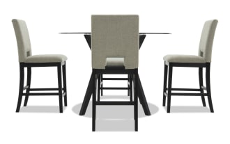 Modern dining set with four beige upholstered chairs featuring black wooden legs and a round glass tabletop with black angled wooden base, ideal for contemporary interiors.