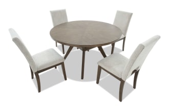 Round wooden dining table with dark brown finish and four beige upholstered chairs, featuring cushioned seats and wooden legs, ideal for modern dining rooms.