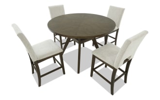 Round wooden dining table set with four beige upholstered chairs, featuring dark wood frames and cushioned seats, suitable for kitchen or dining room.