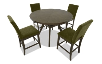 Dining set with a round wooden table and four olive green upholstered chairs featuring dark wood legs and footrests, modern style.