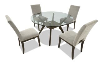 Round dining table set with a glass top and dark wood base, paired with four beige upholstered chairs with wooden legs, modern style.