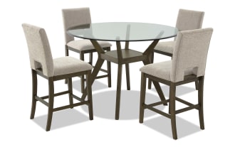 Round glass-top dining table set with four beige upholstered chairs, featuring wooden legs and modern design for kitchen or dining room.