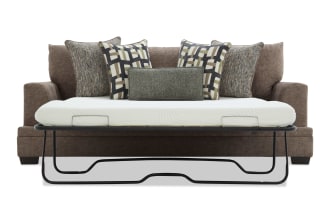 Brown fabric sofa with a pull-out metal frame bed and white mattress, featuring five decorative patterned cushions for added comfort and style.