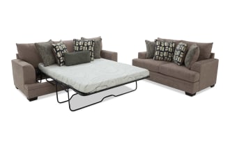 Brown fabric sofa sleeper with geometric and textured throw pillows, featuring a pull-out mattress and sturdy black metal frame, modern style.